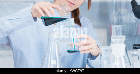 A female laboratory assistant mixes reagents in a chemical laboratory Stock Photo