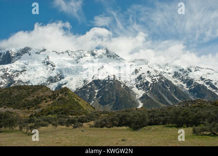 Stunning Hooker Valley in Southern Alps, snow capped Mount Sefton and range, an avalanche of snow, whispy clouds against blue sky. Spring/summer. Stock Photo