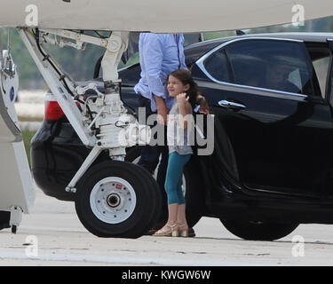 MIAMI, FL - MAY 17:  Suri Cruise seems to be a fashion diva wearing her high heels as she boards her private Gulfstream Jet. Dad Tom Cruise, and mom Katie Holmes accompanied Suri on her flight.  on May 17, 2011 in Miami , Florida   People:  Tom Cruise Suri Cruise Katie Holmes Stock Photo