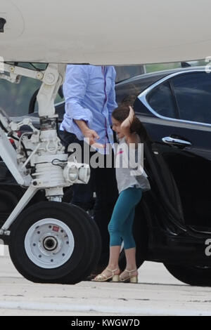 MIAMI, FL - MAY 17:  Suri Cruise seems to be a fashion diva wearing her high heels as she boards her private Gulfstream Jet. Dad Tom Cruise, and mom Katie Holmes accompanied Suri on her flight.  on May 17, 2011 in Miami , Florida   People:  Tom Cruise Suri Cruise Katie Holmes Stock Photo