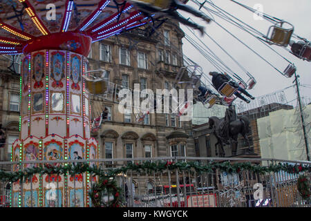 People on a fairground swing ride at the Christmas market, George Square, Glasgow, Scotland Stock Photo