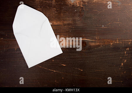 a blank empty card envelop on a wooden table background with copyspace to the left Stock Photo