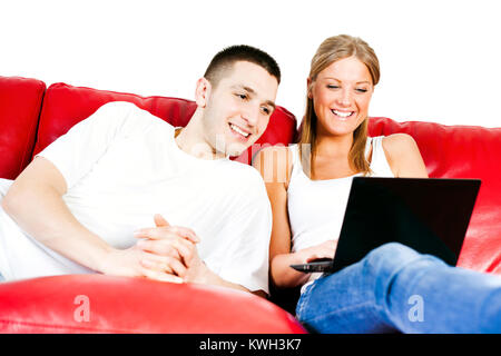 Happy couple using laptop at home Stock Photo