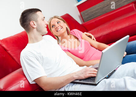 Happy couple using laptop at home Stock Photo