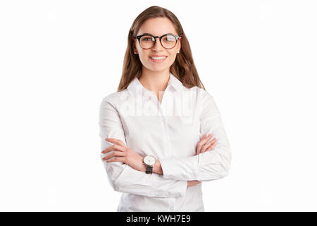 A happy young woman standing with arms crossed at isolated white background. Stock Photo