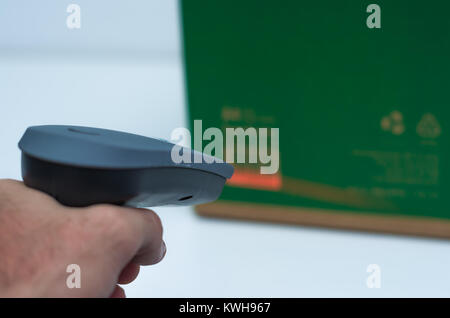 Great concept of traceability, ERP system, hand crawling product barcode and packaging. The man gets on the hip scanner in operations directed on prin Stock Photo