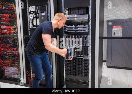 Computer Engineer Installing Server Into Blade Enclosure Stock Photo