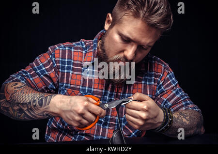 Man working with leather using crafting sciccors Stock Photo