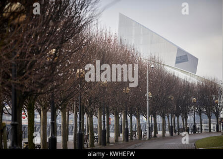 Winter at Trafford Park's Imperial War Museum North (IWM North) seen over the tree lined Salford Quays by architect Daniel Libeskind Stock Photo