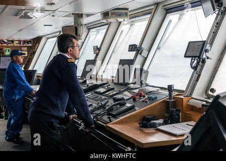 Ship's crew on bridge sailing passenger ship Ocean Adventurer; carries alpine mountaineering skiers to Antarctica Stock Photo