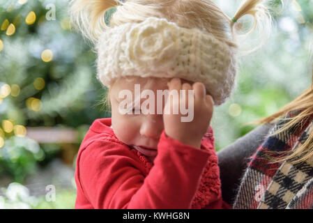 woman holding sick child with runny nose and bad cold in winter Stock Photo