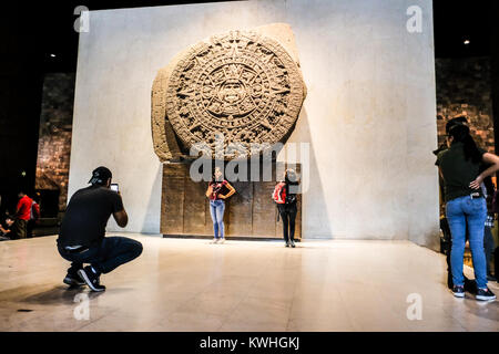 Tourist posing in front of the Sun Stone at the National Museum of Anthropology of Mexico
