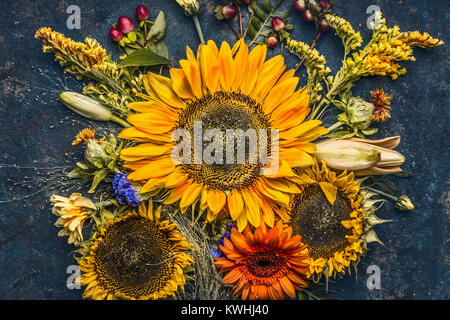 Autumn flowers and leaves composition with sunflowers on dark rustic background , top view, fall nature Stock Photo