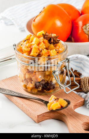 Traditional indian food recipes, Persimmon fruit Chutney with cinnamon and anise stars, white marble background copy space Stock Photo