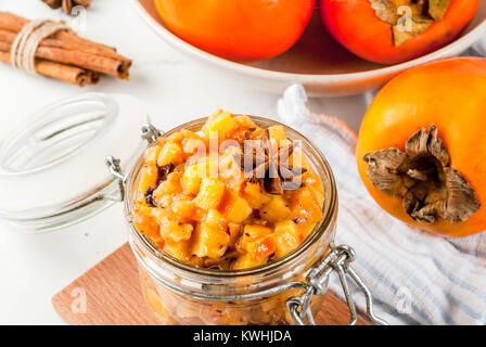 Traditional indian food recipes, Persimmon fruit Chutney with cinnamon and anise stars, white marble background copy space Stock Photo