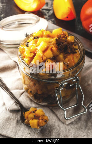 Traditional indian food recipes, Persimmon fruit Chutney with cinnamon and anise stars, dark rusty background copy space Stock Photo