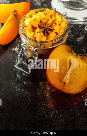 Traditional indian food recipes, Persimmon fruit Chutney with cinnamon and anise stars, dark rusty background copy space Stock Photo