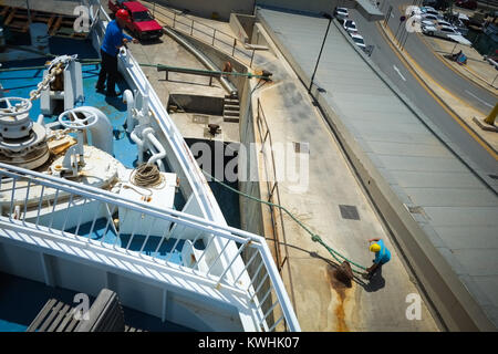 Two men working on the Gozo Channel Company ferry as it arrives into Mgarr Port, Gozo, from Malta Stock Photo