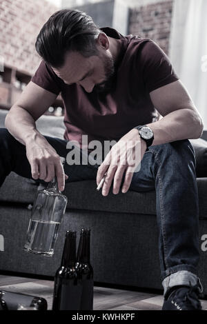 Cheerless drunk man holding a bottle of vodka Stock Photo