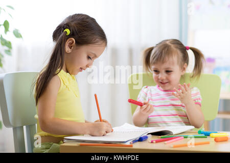 happy children drawing in nursery room