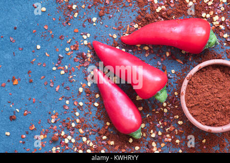 Capsicum. Red chili peppers, Chili powder and dried chili flakes on slate