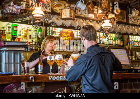 Barmaid and waiter pouring Belgian beers in beer glasses in Flemish café De Dulle Griet in the city Ghent, East Flanders, Belgium Stock Photo