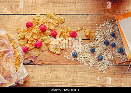 Golden corn flakes, Hercules oat and some on a wooden table. Stock Photo