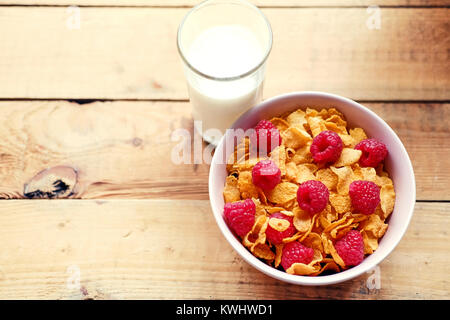 Diet corn flakes with raspberry and glass with milk on a wooden  Stock Photo