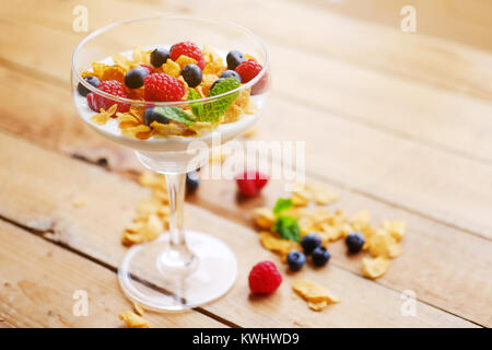 Crunchy corn flakes with some wild berries in a glass cup. Stock Photo