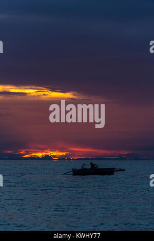 Fisherman reeling in his nets at sunset Stock Photo