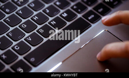 Young woman uses laptop to electronically pay bills with her credit card Stock Photo
