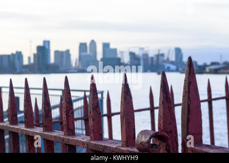 Rusty gate with Canary Wharf, a major business district in London, in the background for concept use Stock Photo