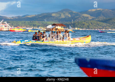 BORACAY ISLAND, PHILIPPINES - November 18, 2017 : Tourists ride a Banana Boat on Boracay sea Stock Photo