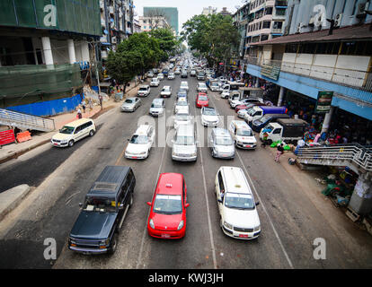 Yangon, Myanmar - Feb 26, 2016. Cars running on street at downtown in Yangon, Myanmar. Yangon is Myanmar largest city and its most important commercia Stock Photo