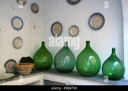Old demijohns and wall plates in a tradirtional old kitchen Stock Photo