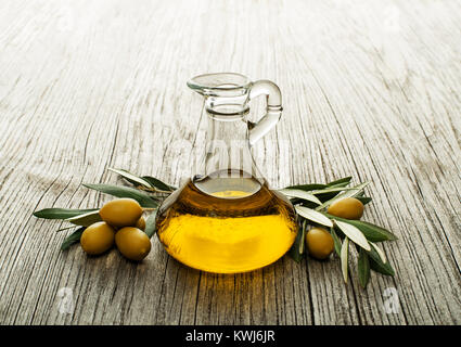 Olive oil and olive branch on wooden table Stock Photo