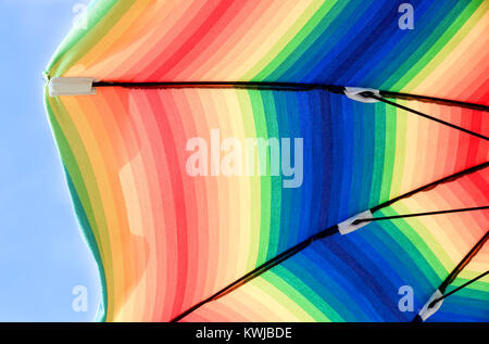 View from under the sunshade with space for copyBeach colorful umbrella with blue sky and sunlight. Stock Photo