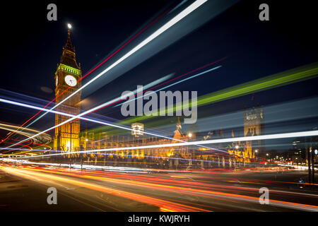 Streaks of light from moving vehicles pass in front of The Houses of Parliament seen from Westminster Sq at dusk Stock Photo