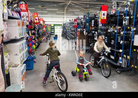 Children ride new bikes on sale in Decathlon store / shop / sports equipment retailer in France / French superstore at Grésy-sur-Aix. France. (93) Stock Photo
