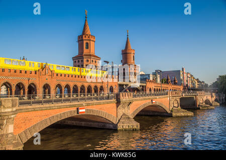 Classic panoramic view of famous Oberbaum Bridge with historic Berliner U-Bahn crossing the Spree river on a beautiful sunny day in Berlin, Germany Stock Photo