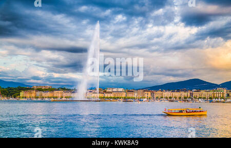 Panoramic view of historic Geneva skyline with famous Jet d'Eau fountain at harbor district in beautiful evening light at sunset, Switzerland Stock Photo