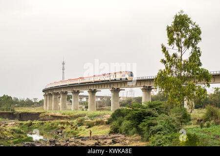 The Madaraka Express Passenger Service train travelling on a viaduct section of the Nairobi to Mombasa Standard Gauge Railway SGR, Kenya Stock Photo