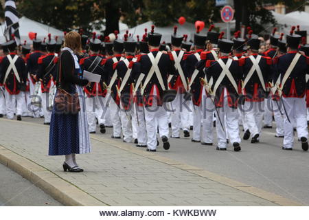 A woman in traditional dress watches a marching band take part in the Oktoberfest parade in Munich. Stock Photo
