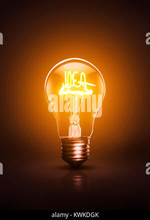 Warm colored IDEA written active bulb on a dark background. Stock Photo