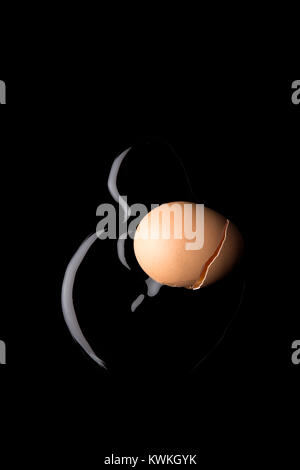 Concept image of a cracked egg on a black background Stock Photo
