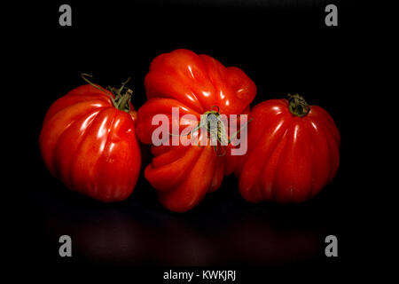 Three large beefsteak tomatoes on a black background Stock Photo