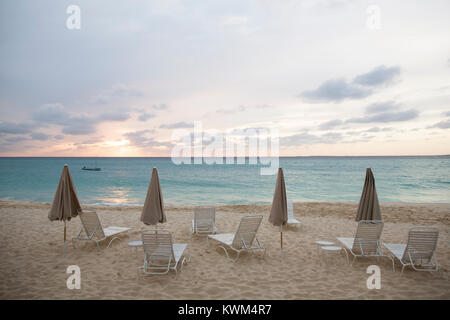 Scenic view of parasols and lounge chairs at beach against cloudy sky Stock Photo