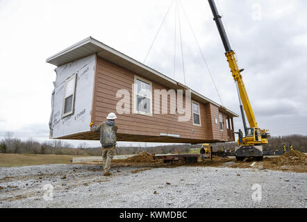 Davenport, Iowa, USA. 30th Nov, 2016. A crew with Design Homes Inc. hoists a half of the first cabin into place as it arrives at West Lake Park in Davenport on Wednesday, November 30, 2016. West Lake Park welcomes two new pre-constructed cabins to be set on a plot of land overlooking Railroad Lake. Credit: Andy Abeyta/Quad-City Times/ZUMA Wire/Alamy Live News Stock Photo