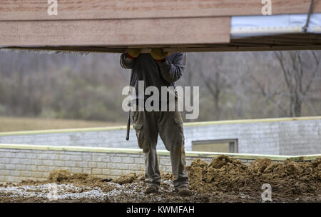 Davenport, Iowa, USA. 30th Nov, 2016. A man pulls a half of the cabin to rotate it into position at West Lake Park in Davenport on Wednesday, November 30, 2016. West Lake Park welcomes two new pre-constructed cabins to be set on a plot of land overlooking Railroad Lake. Credit: Andy Abeyta/Quad-City Times/ZUMA Wire/Alamy Live News Stock Photo