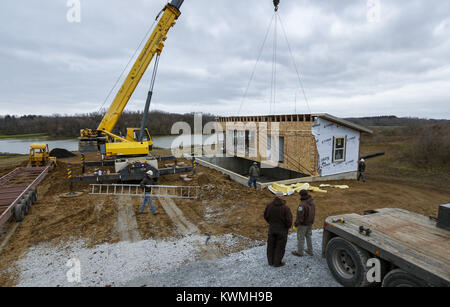 Davenport, Iowa, USA. 30th Nov, 2016. Crews work to set the first half of one of the two cabins into place on its foundation at West Lake Park in Davenport on Wednesday, November 30, 2016. West Lake Park welcomes two new pre-constructed cabins to be set on a plot of land overlooking Railroad Lake. Credit: Andy Abeyta/Quad-City Times/ZUMA Wire/Alamy Live News Stock Photo